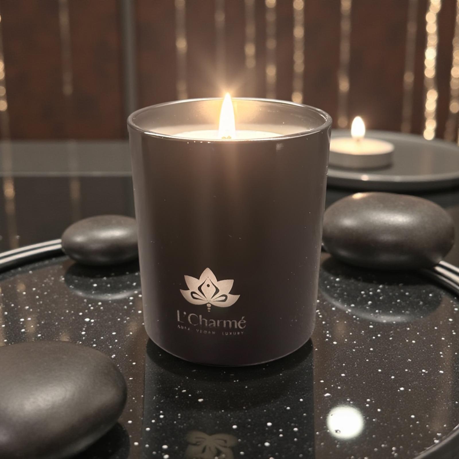 L’Charmé Duftkerze Schwarz Matt auf dunklem Tablett mit Dekosteinen.