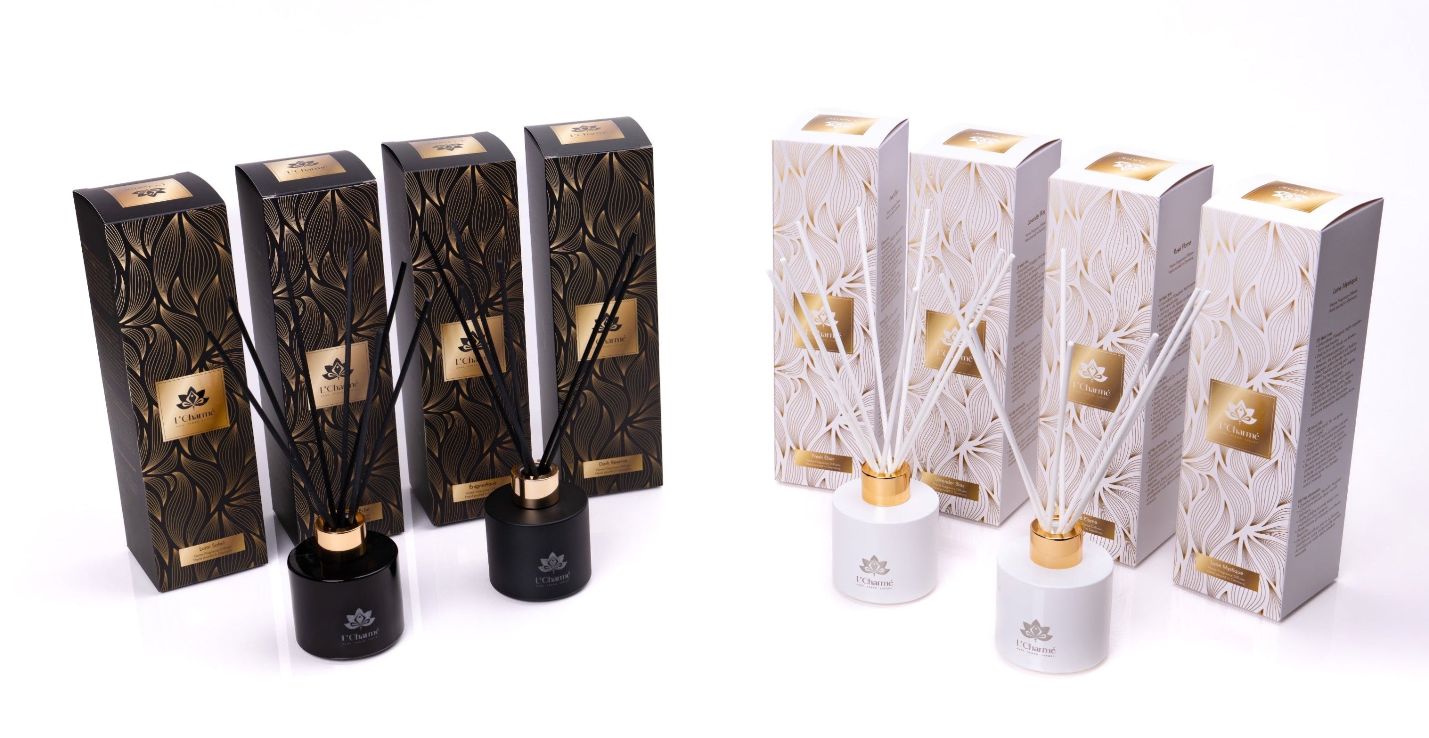L’Charmé Duftstäbchen Sortiment: schwarze und weiße Diffuserflakons mit Stäbchen vor passenden Geschenkboxen in Schwarz/Gold und Weiß/Gold, Produktfoto auf weißem Hintergrund