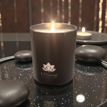 L’Charmé Duftkerze Schwarz Matt auf dunklem Tablett mit Dekosteinen.